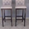 Banqueta de madera con respaldo y asiento tapizados.