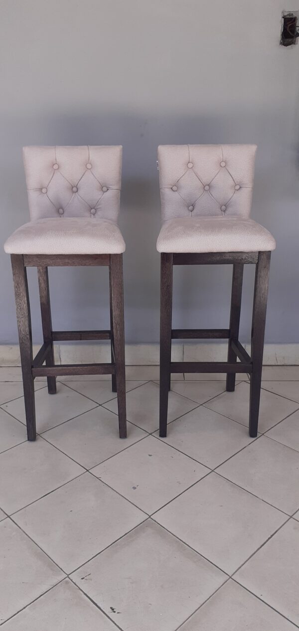Banqueta de madera con respaldo y asiento tapizados.