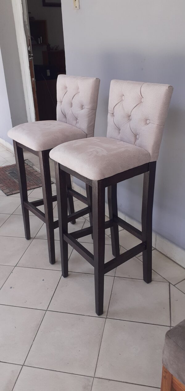 Banqueta de madera con respaldo y asiento tapizados.