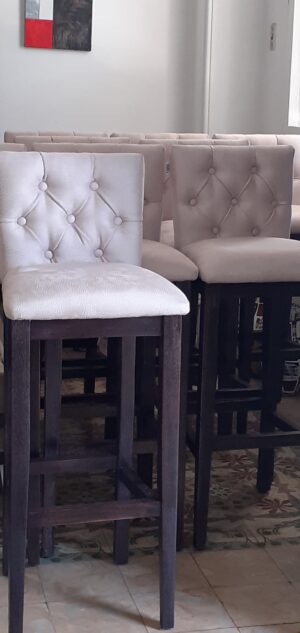 Banqueta de madera con respaldo y asiento tapizados.