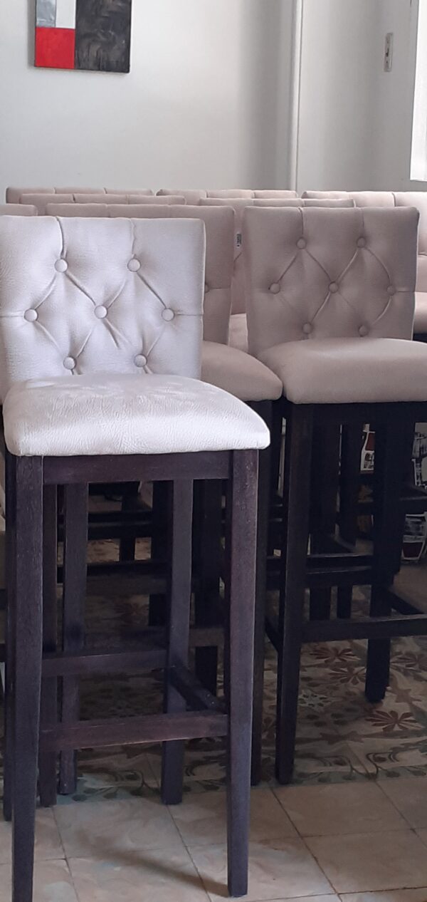 Banqueta de madera con respaldo y asiento tapizados.